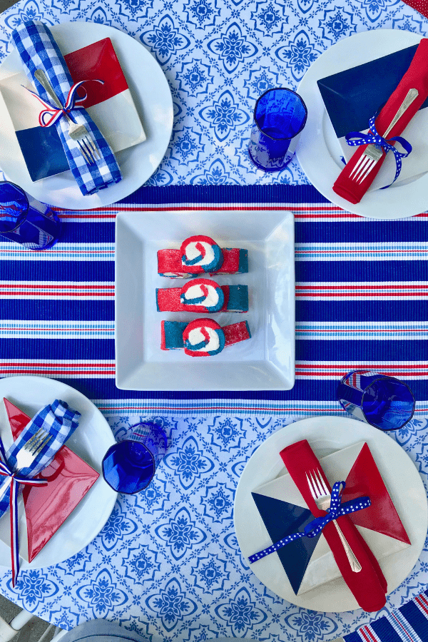 Overhead shot of red white blue tablescape featuring mini cake rolls lizbushong.com